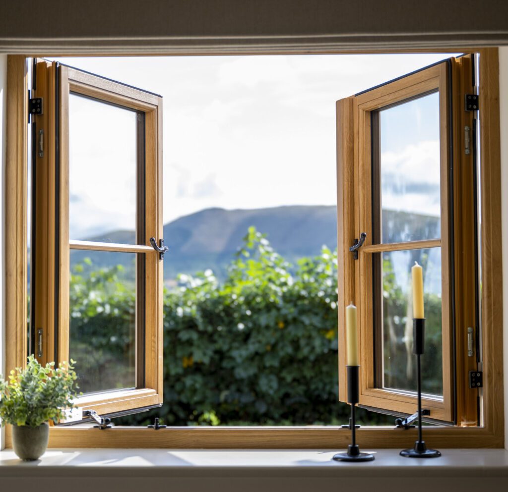 A window showcasing a serene view of mountains and trees, part of a residence collection.